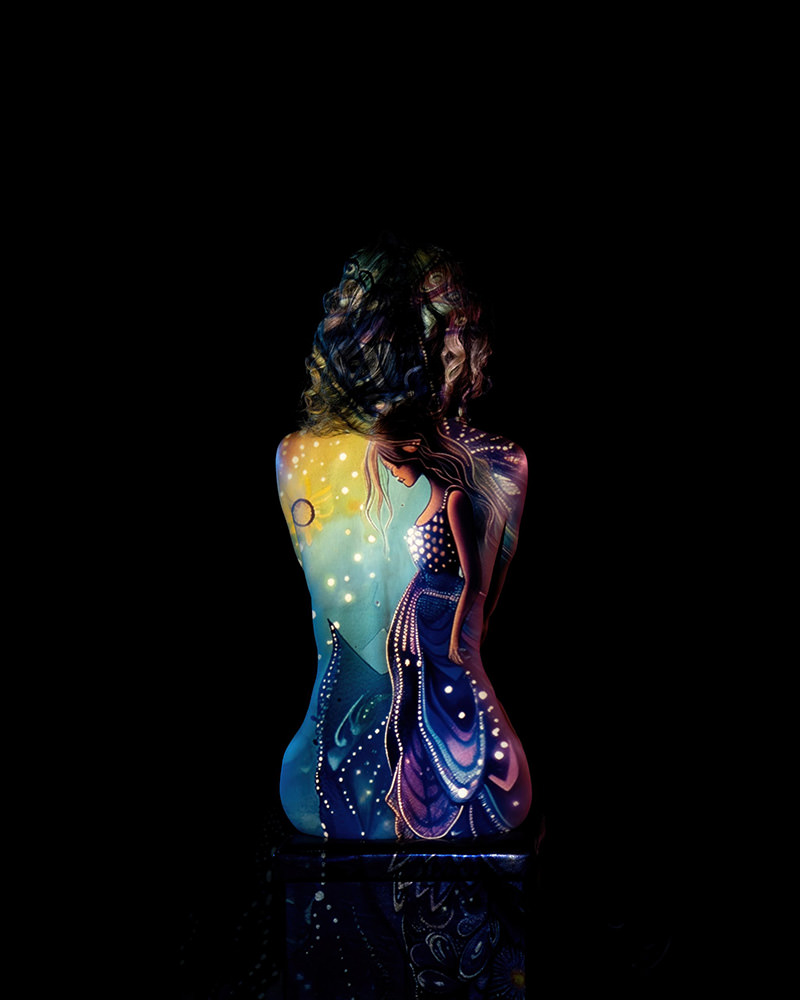 Curly-haired person with a colorful projection of a mystical woman in a blue dress on their back against a black background