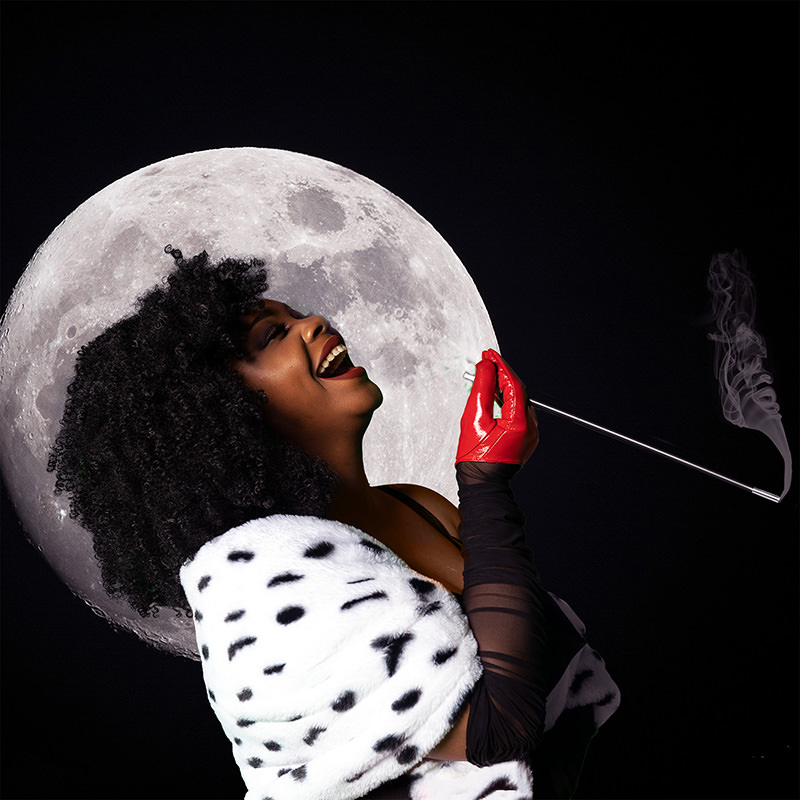 Woman with curly black hair laughing, wearing red gloves and a spotted white fur shawl, holding a long cigarette holder emitting smoke, with a large full moon in the background against a dark sky